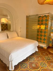 a bedroom with a white bed and a colorful wall at Villa Mary Suites in Positano