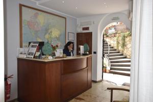 una mujer en una recepción en el vestíbulo del hotel en Hotel Condor, en Taormina