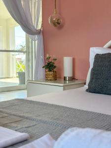 una camera da letto con un letto con una candela e una finestra di LefCoast AURA Apartments a Tragasiá