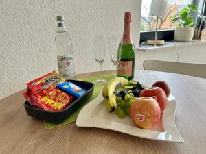 un piatto di frutta su un tavolo con una bottiglia di vino di Ferienwohnung Stengel a Schotten