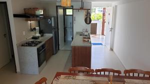 eine Küche mit Herd und Tisch mit Stühlen in der Unterkunft Porto Beach Flat in Porto De Galinhas