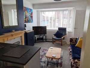 a living room with a couch and a tv at Semi detached quite location in Bridlington +12 photos