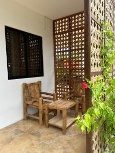 patio z 2 krzesłami, stołem i ławką w obiekcie Sunset Ocean View @ Breeze Life. w Panglao City
