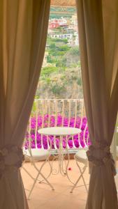 uma vista para uma mesa e cadeiras a partir de uma janela em Villa Mary Suites em Positano