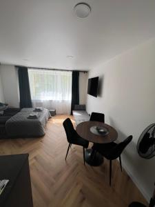 a living room with a bed and a table and chairs at Hygge Apartments in Druskininkai