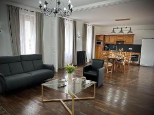 a living room with a couch and a table at Le Domaine du Castel in Saulzoir