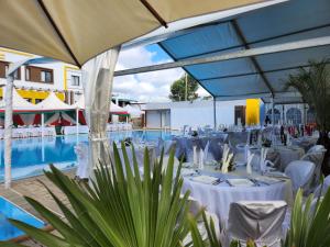 a banquet hall with white tables and a pool at MANGORO HOTEl in Moramanga