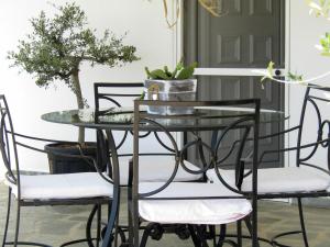 a glass table and chairs with a plant on it at LefCoast AURA Apartments in Paralía Avdhíron