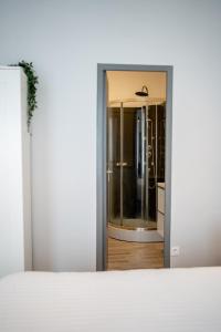 une porte ouverte menant à une chambre avec une porte en verre dans l'établissement Villa Vichéia - Appartement 23, à Vichy
