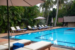 瓦伊卡爾的住宿－Ging Oya Lodge，一个带躺椅和遮阳伞的游泳池