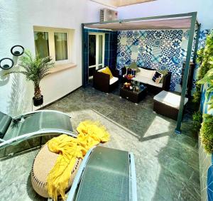 una sala de estar con una manta amarilla en el suelo en Elegante Apartamento TRES COLORES, en Alicante