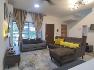 a living room with two couches and yellow pillows at Homestay Banting Selangor in Banting