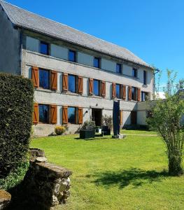 ein großes Gebäude mit einer Rasenfläche davor in der Unterkunft Vacances en famille 4 étoiles à 30min des pistes de Ski Mont Dore Sancy in Messeix