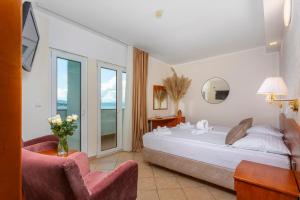 a hotel room with a bed and a chair at Hotel Adria in Malinska