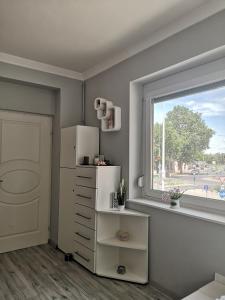 eine Küche mit einem weißen Kühlschrank und einem Fenster in der Unterkunft Centrum Luxus Apartman in Makó