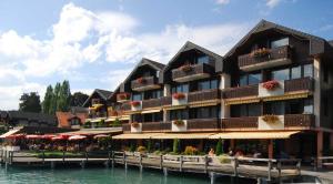 a hotel on the water next to a body of water at Hotel-Restaurant Seegarten-Marina in Spiez