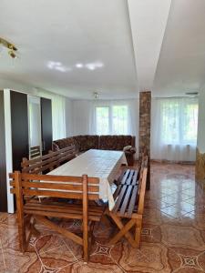 a dining room with a table and a couch at Casa de vacanta Bulz in Bulz