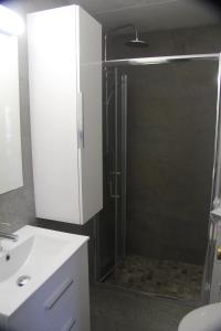ein Bad mit einer Dusche und einem weißen Waschbecken in der Unterkunft Aparthotel Els Molins in Roses
