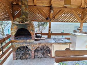 an outdoor kitchen with a stone oven in a pavilion at Casa de vacanta Bulz in Bulz