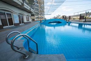 a large blue swimming pool in front of a building at AIFU Hotel El Montazah Alexandria in Alexandria