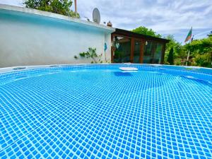 a blue tile swimming pool with a house at Guest House Devetaki in Devetaki