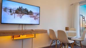 a living room with a flat screen tv on a wall at Amazing View Of Acropolis in Athens