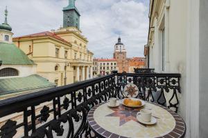 una mesa en un balcón con tazas de café y pan en Apartamenty Lalka by ShortStayPoland, en Lublin