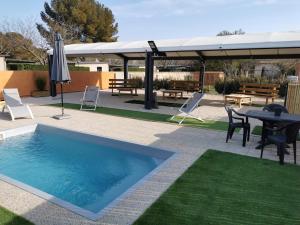 a swimming pool with a table and chairs and an umbrella at tony vacances in Martigues