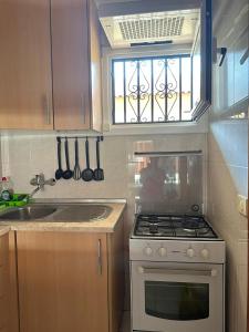 a kitchen with a stove and a window with utensils at Los Angeles in Los Cristianos +12 photos