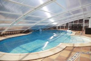 a large swimming pool in a building with a ceiling at Apartamentos La Arena in Miengo