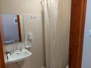 baño con lavabo y cortina de ducha en The Santo George Beach Resort, en Amoudara Herakliou
