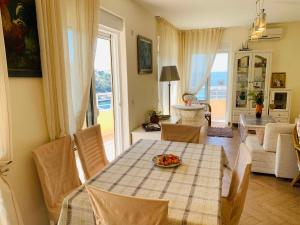 a dining room with a table and chairs and a living room at Villa Vega in Kruče