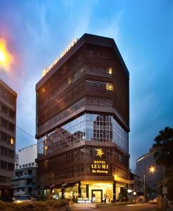 a tall building with a sign on it at Izumi Hotel Bukit Bintang Kuala Lumpur in Kuala Lumpur