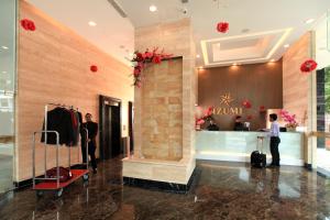 two people standing in a store lobby with luggage at Izumi Hotel Bukit Bintang Kuala Lumpur in Kuala Lumpur