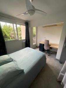 a bedroom with a bed and a desk and a fan at Chambre avec Salle de bain privée dans appartement partagé in Montpellier