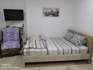 a small bedroom with a bed and a tv at Квартира-студия с видом на море in Ureki