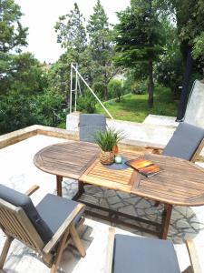 een patio met een houten tafel en stoelen bij Corina & Franco in Senj