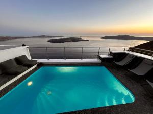 a swimming pool on top of a house with the ocean at Hara's houses in Imerovigli