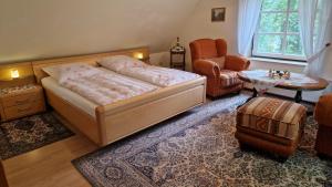 1 dormitorio con 1 cama, 1 silla y 1 mesa en 4 Sterne-Haus am See en Waren