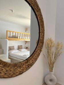 un espejo colgado en una pared de un dormitorio en BLUE IN NAXOS en Naxos