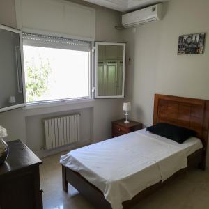 - une chambre avec un lit et une grande fenêtre dans l'établissement Villa Sérénité, Yasmine Hammamet, à Hammamet