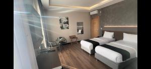 a hotel room with two beds and a window at Niconya Port Suite&Hotel in Istanbul