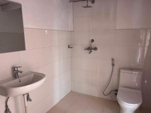 biała łazienka z umywalką i toaletą w obiekcie Hotel Dancing Yak w mieście Lete