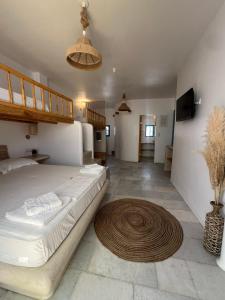a bedroom with a large bed and a rug on the floor at BLUE IN NAXOS in Naxos Chora