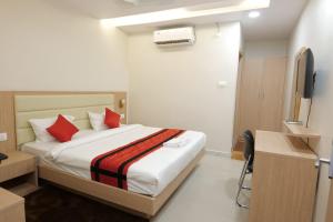 1 dormitorio con 1 cama con almohadas rojas y TV en INDRALOK INN., en Hazārībāg