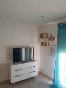 a living room with a tv on a dresser at Dépendance 29m2 climatisée in Saint-Gilles