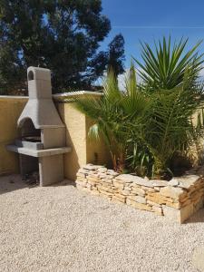 a garden with a stone fireplace and some plants at Dépendance 29m2 climatisée in Saint-Gilles