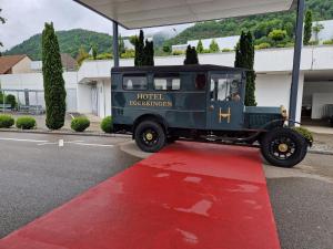 an old green truck parked on a red carpet at Hotel Egerkingen, idealer Zwischenstopp in Egerkingen