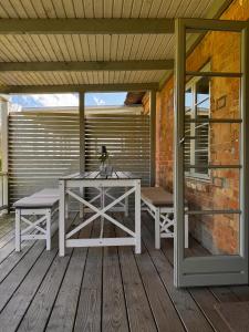 un patio avec une table et des bancs sur une terrasse dans l'établissement Kleine Perle, à Brodersby