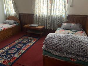 Kleines Zimmer mit 2 Betten und einem Tisch in der Unterkunft Hotel Dancing Yak in Jomsom
